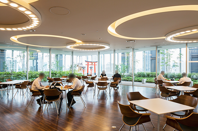 新本社ビル　14階　カフェテラス　屋上庭園を望む開放的な空間で、打ち合わせや加島オフィス棟から来た社員のサテライトスペースなどとしても活用される。